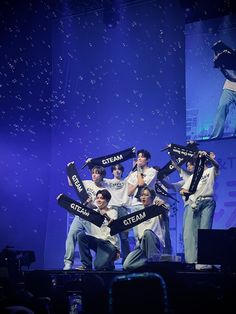 a group of young men standing on top of a stage holding up signs that say dream