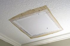 the ceiling is being painted white and has a square hole in it that appears to be missing