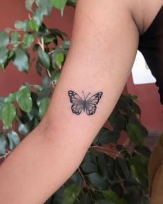 a woman's arm with a small butterfly tattoo on the left side of her arm