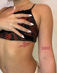 a woman with white nails and a tattoo on her stomach is posing for the camera