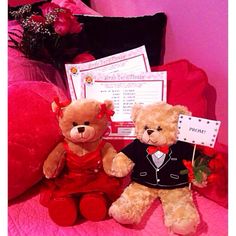 two teddy bears sitting next to each other on a pink bed with pillows and flowers