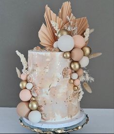 a three tiered cake decorated with gold and white decorations