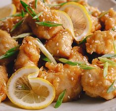 a white plate topped with chicken and lemon slices