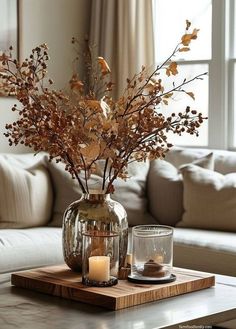 a living room with a couch, table and vase filled with flowers on top of it