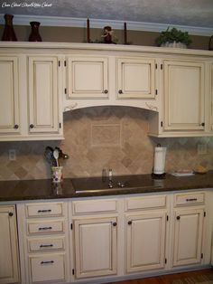 a kitchen with white cabinets and granite counter tops