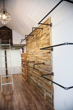 a room with wooden walls and ladders on the wall, next to a light fixture