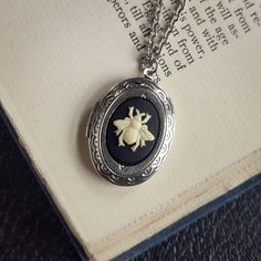 "Cameo on a vintage brass, antiqued or shiny silver-plated oval locket, perfect for remembering your loved ones.  On 28 inches of chain. Choose your desired color.         I can change the chain to any length, just leave a note at checkout. Great for pictures of your loved ones.  Simply print, cut out and attach a photo with glue.  We do not offer printer services at this time.  Fits a 17mm by 24mm oval photo. The box will include an oval stencil that will help you cut out your photo. I carry a Vintage Sterling Silver Oval Locket Necklace, Vintage Oval Sterling Silver Locket Necklace, Nickel Free Antique Silver Oval Jewelry, Oval Silver Necklace With Antique Finish, Nickel-free Antique Silver Oval Jewelry, Antique Silver Locket Necklace For Vintage Collection, Vintage Antique Silver Oval Locket Necklace, Oval Antique Silver Jewelry For Vintage Collection, Silver Cameo Jewelry For Memorial