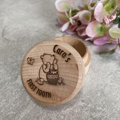 a small wooden box with a cartoon character on it and flowers in the back ground