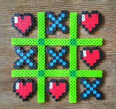 four pieces of perler bead art on a wooden table