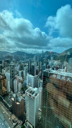 the city is surrounded by tall buildings and mountains in the distance, as seen from an observation point