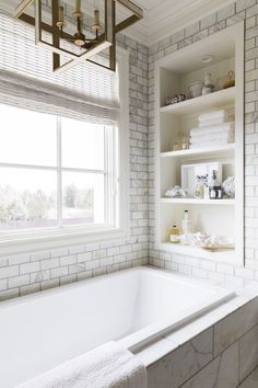 a bathroom with a tub and shelves in it