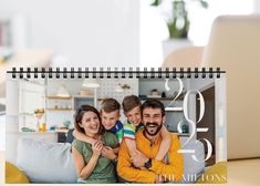 a calendar with a family photo and the date 2013 is shown in front of a laptop