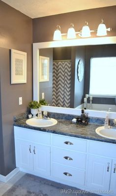 a bathroom with two sinks and a large mirror