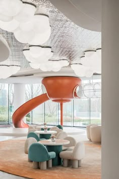 a room with chairs, tables and a slide in the middle of it's ceiling