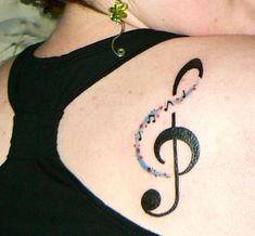 a woman with a music note tattoo on her shoulder