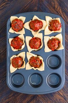 mini pizzas with sauce and cupcake tins on a tray ready to go into the oven