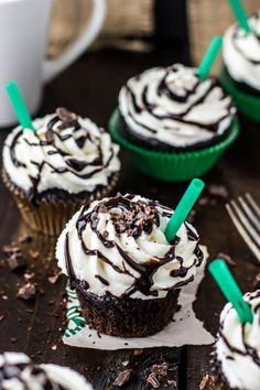 cupcakes with white frosting and chocolate shaving on top, sitting on a table