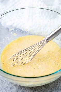 a glass bowl filled with batter and whisk