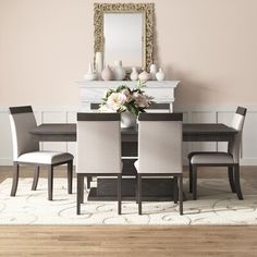 a dining room table with chairs and a mirror