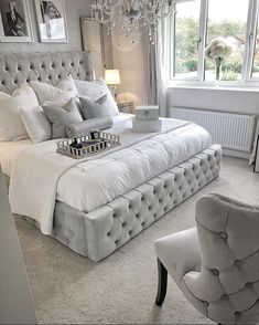 a bedroom with a large white bed and chandelier