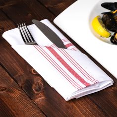 a plate with mussels on it next to a glass of water and a fork