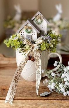 a mug with some flowers in it and a ribbon on the handle that says home