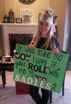 a girl holding a sign that says, if would make me so happy if you'd roll with me to sadies?