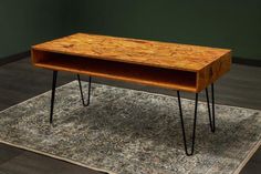 a wooden table with black hairpinks on it's legs sitting on a rug