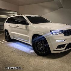 a white jeep parked in a parking garage