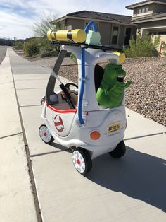 a toy car with a dinosaur riding on the front and back wheels that is attached to it's handlebars