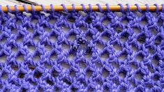 a close up view of a purple crochet stitch with the word w on it