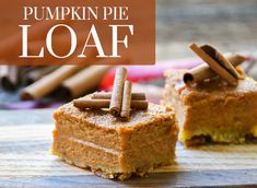 two pieces of pumpkin pie sitting on top of a wooden cutting board with cinnamon sticks