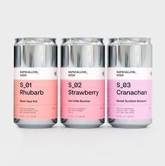 three cans of pink and white soda on a grey background