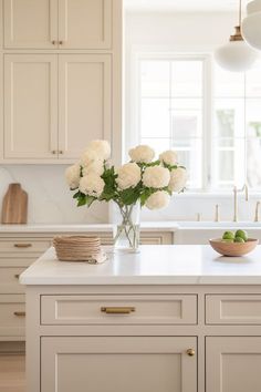 white flowers in a vase on a kitchen island