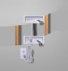 two electrical wires are plugged into an outlet in the middle of a gray wall