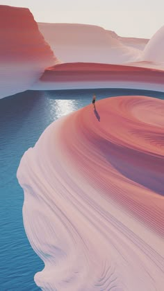 a person standing on the edge of a body of water in front of mountains and sand dunes