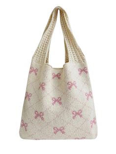 a white knitted bag with pink bows on the front and bottom, sitting against a white background