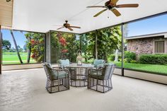 a dining room with glass walls and ceiling fans