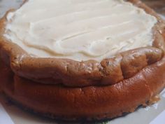 a cake with white frosting sitting on top of a piece of plastic wrapper