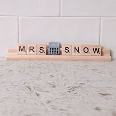 a wooden scrabble with the word mrs snow spelled in it