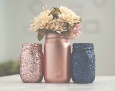 three different colored vases with flowers in them