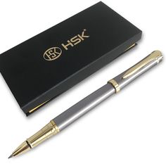 a pen sitting next to a black box with gold trimmings on the end