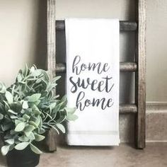 a potted plant sitting on top of a counter next to a white towel that says home sweet home