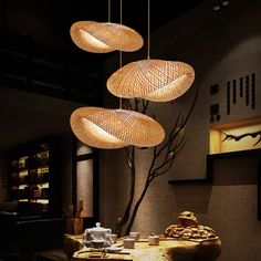 three lights hanging from the ceiling above a table in a room with chairs and tables