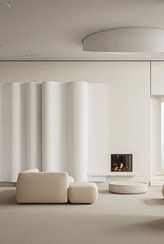 a living room with white furniture and a fire place in the middle of the room