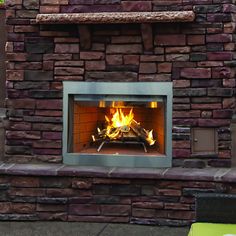 a brick fireplace with fire burning in it