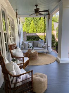 a porch with wicker furniture on it and a ceiling fan hanging from the ceiling