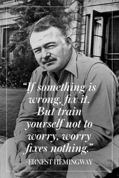 a man sitting in front of a building with a quote on it that says, if something is wrong, but you're yourself not to worry