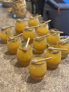 small jars filled with yellow liquid sitting on top of a counter