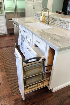 an open dishwasher in the middle of a kitchen with white cabinets and stainless steel appliances